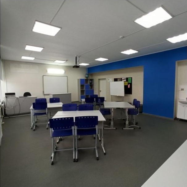 Класс с синей мебелью — стеллаж, доска, парты