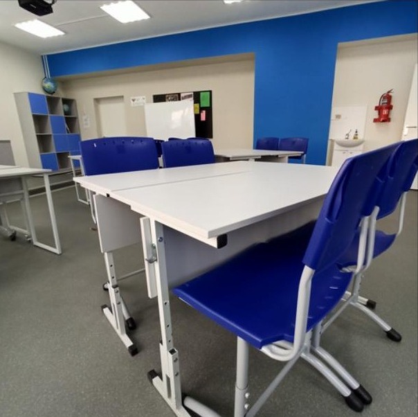 Складные парты с синими стульями крупным планом