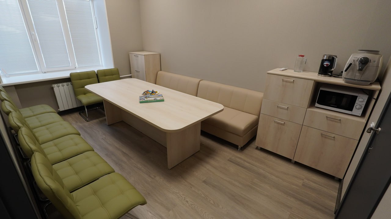 Комната отдыха — мягкий диван, кофемашина, зелёные кресла